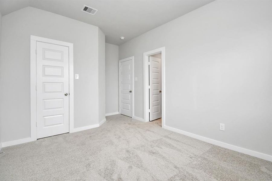 Secondary bedroom features plush carpeting, large windows that let in plenty of natural light, bright paint, and spacious closets. Sample photo of completed home with similar floor plan. Actual colors and selections may vary.