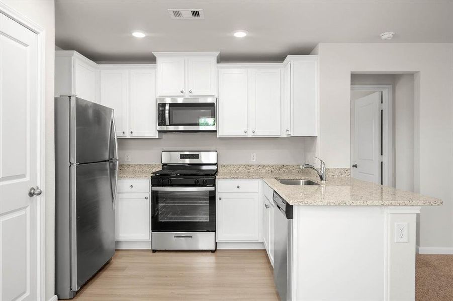 The open and bright kitchen come equipped with a full suite of kitchen applicances!