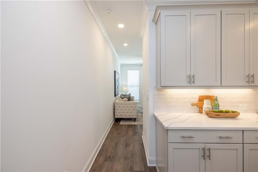 Hall featuring dark wood-type flooring and ornamental molding