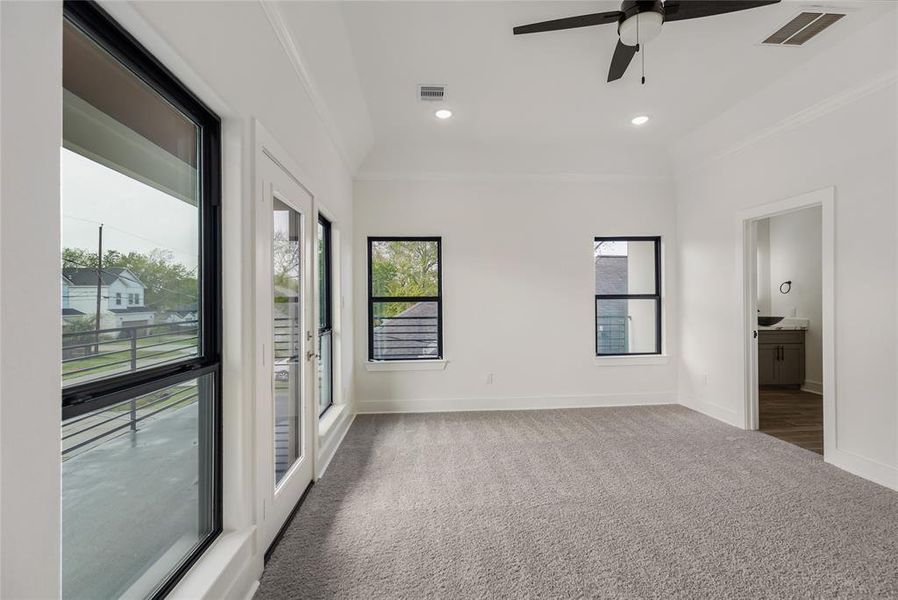 The Primary bedroom is nice and bright, with recessed lighting, a modern fan, and plenty of natural light through the windows overlooking the balcony