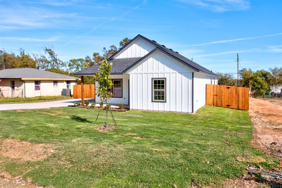 View of front of house with central air condition unit and a front lawn