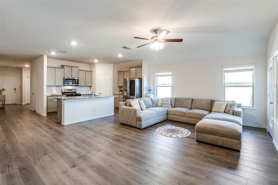 Living room featuring hardwood / wood-style floors, a healthy amount of sunlight, sink, and ceiling fan