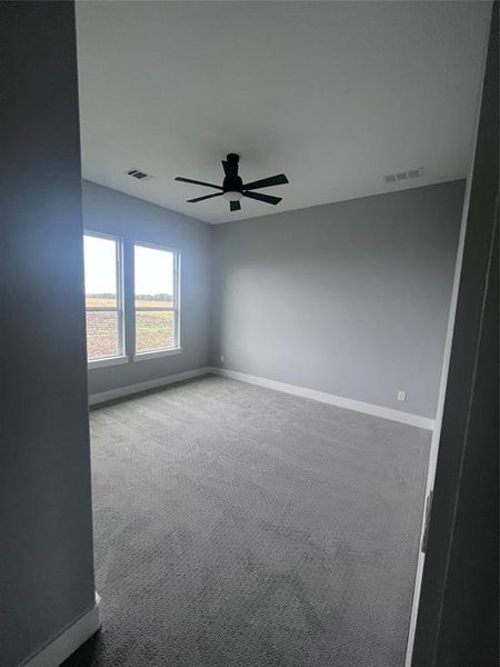 Carpeted spare room featuring ceiling fan