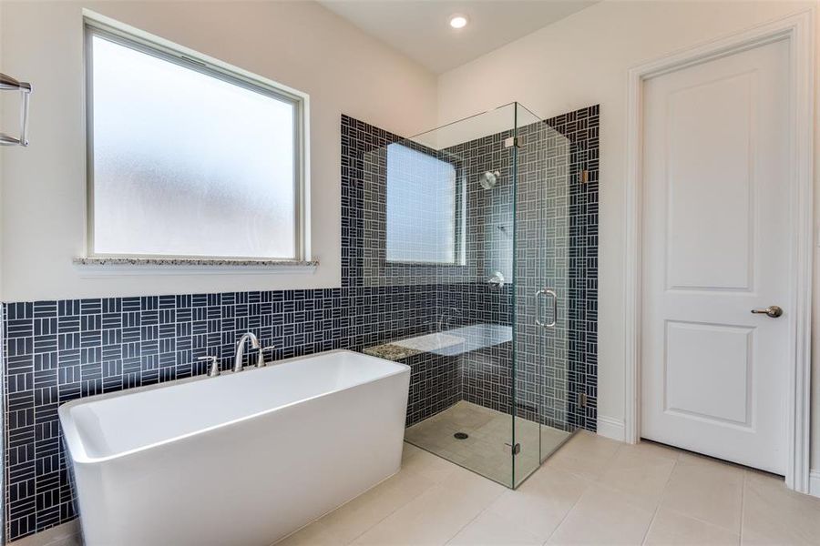 Gorgeous tub with separate shower, upgraded high level tile and separate shower with bench.
