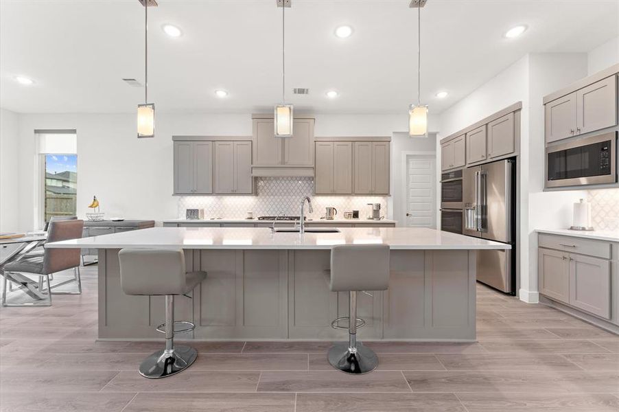 The kitchen is a chef’s dream, designed with a massive quartz island (over 11 feet) that serves as both a workspace and a gathering spot.