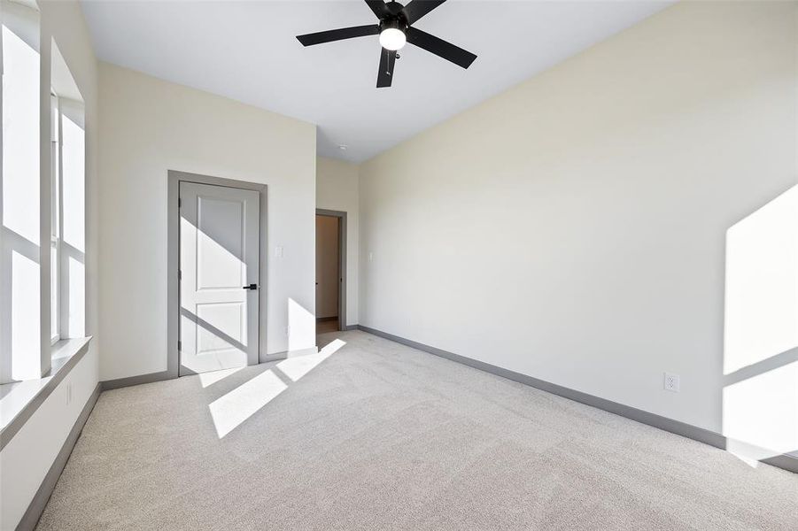 Spare room featuring light carpet and ceiling fan