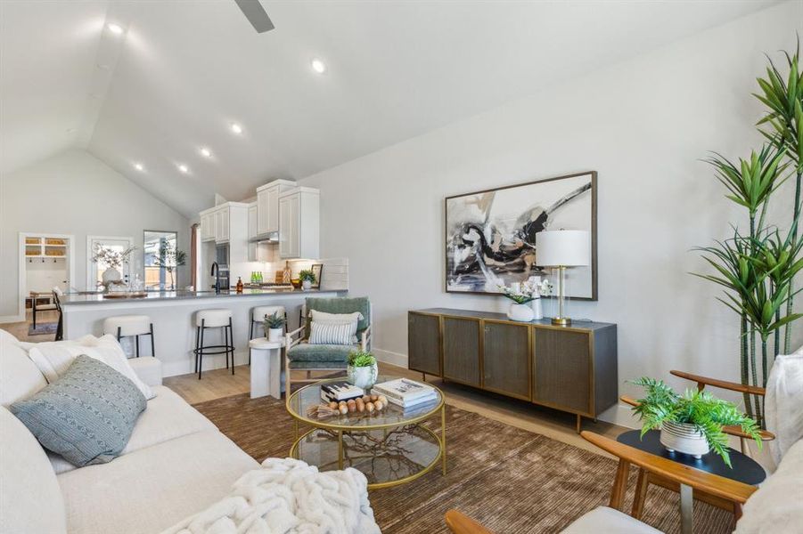 Living room featuring ceiling fan, sink, light wood-type flooring, and vaulted ceiling