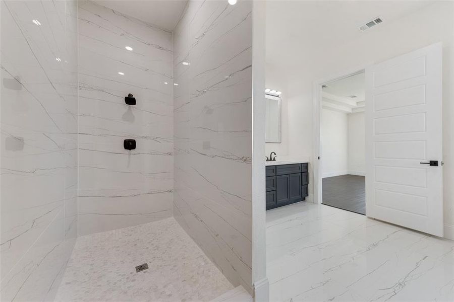 Bathroom featuring vanity and tiled shower