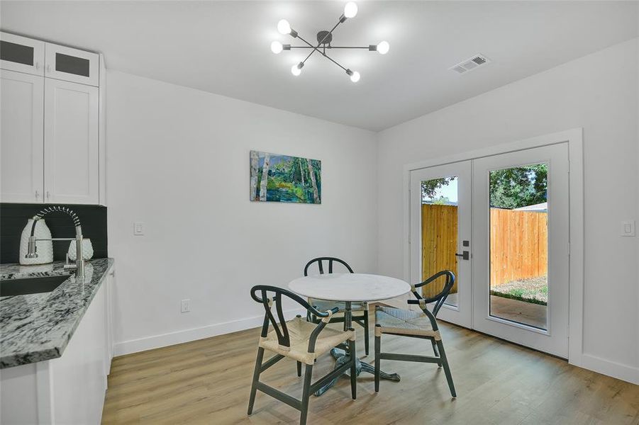 Dining area featuring a notable light fixture, light wood-type flooring