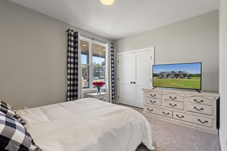 Bedroom with light carpet and a closet