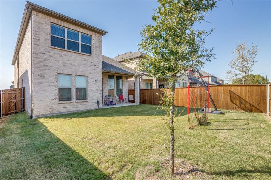 Back of house with a yard and a patio