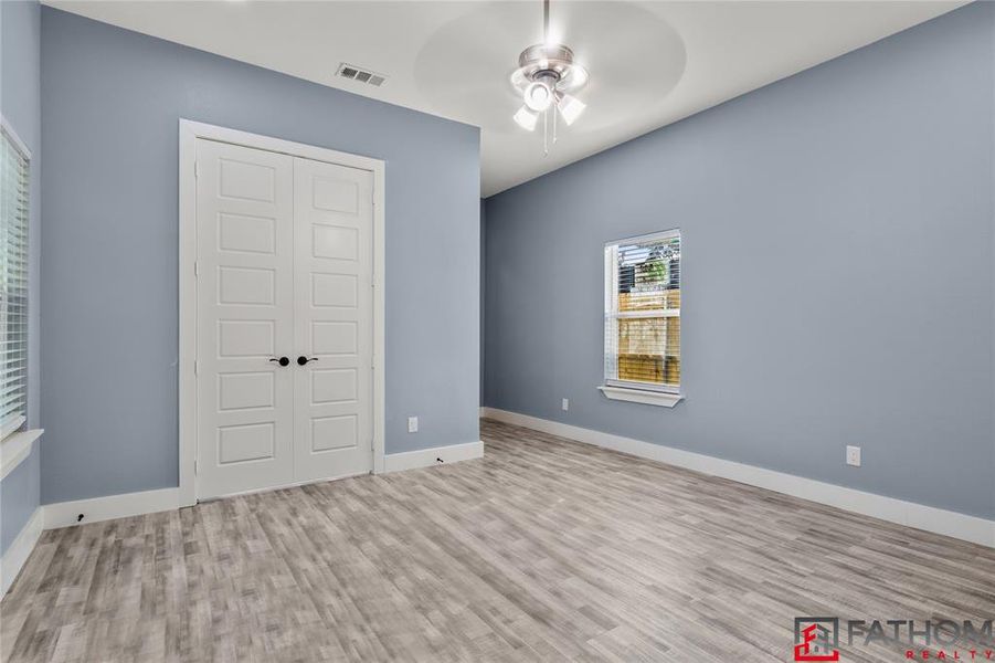 Unfurnished bedroom featuring ceiling fan, a closet, and light hardwood / wood-style floors