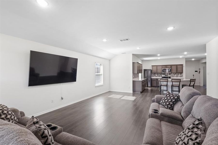 Living room with dark hardwood / wood-style flooring and lofted ceiling