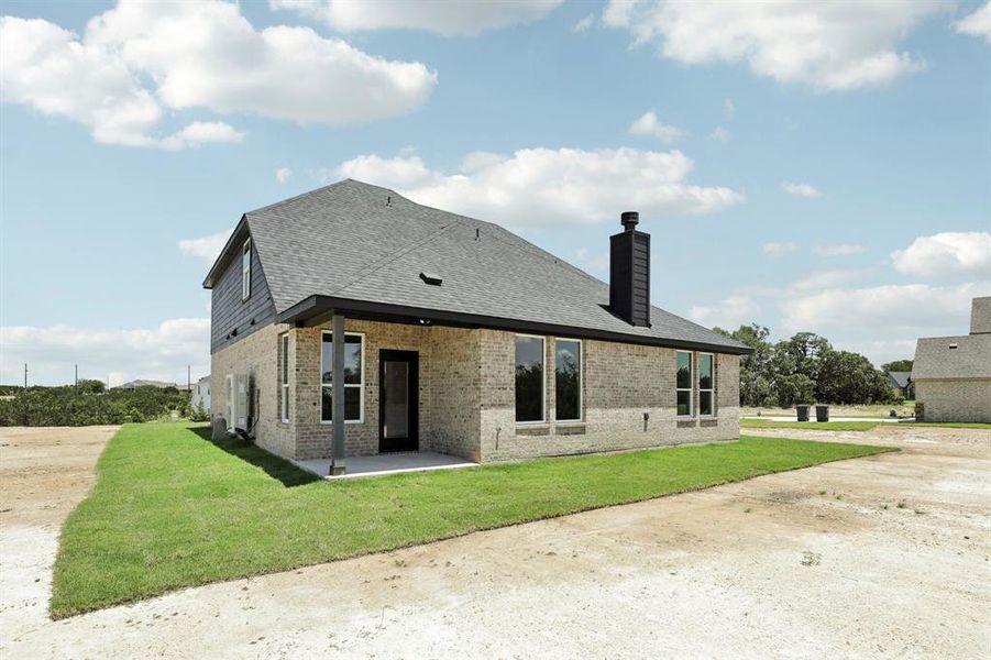 Rear view of house featuring a yard and a patio area