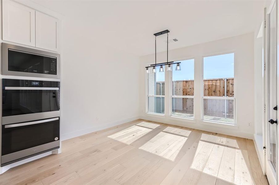 Unfurnished dining area with light hardwood / wood-style floors and a chandelier