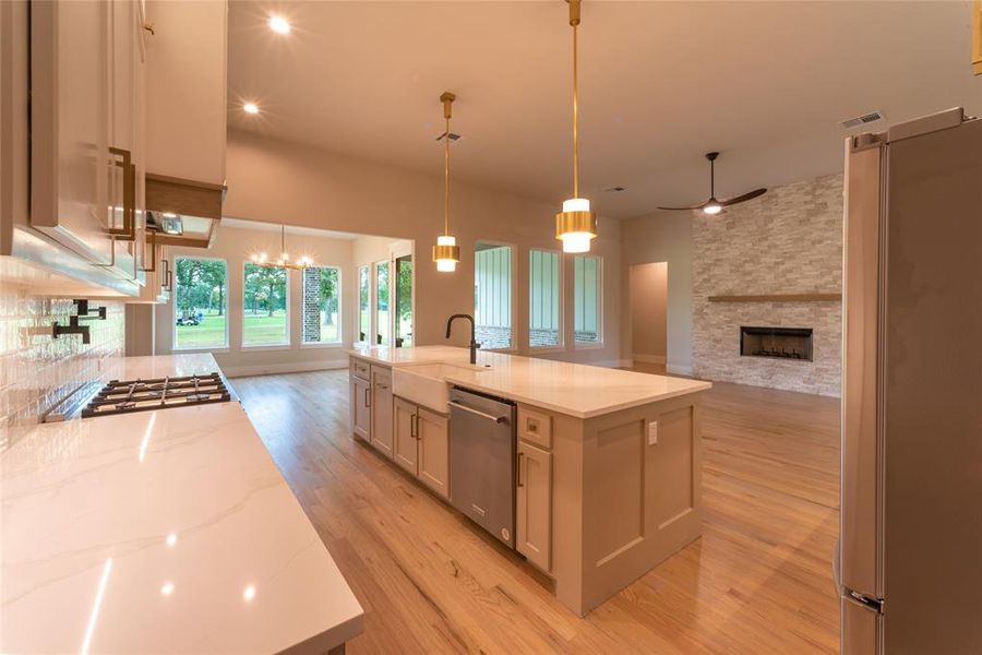 Kitchen from garage showing beautiful ledger stone fireplace.