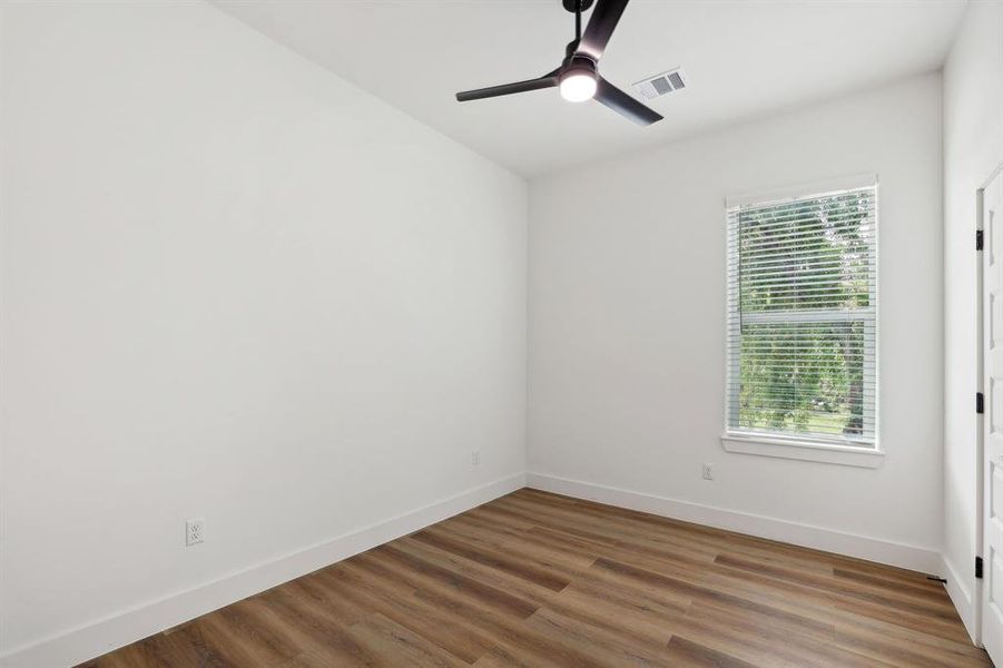 Bedroom 3 with with large walk-in closet and all wood flooring.