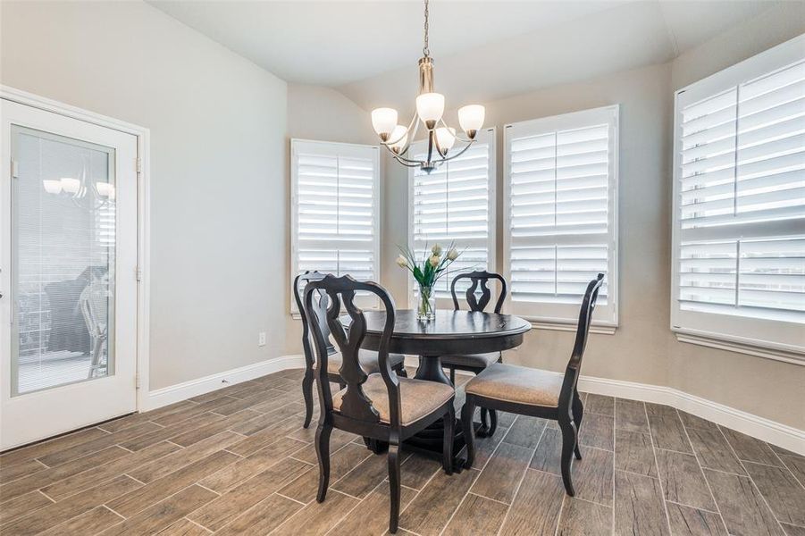 Dining room featuring an inviting chandelier, dark wood-type flooring, and lofted ceiling