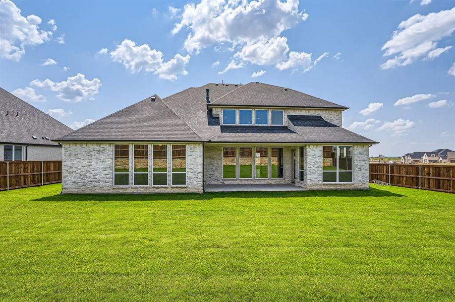 Rear view of property with a lawn