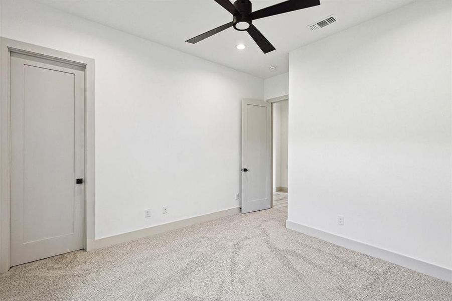 Unfurnished room with ceiling fan and light carpet