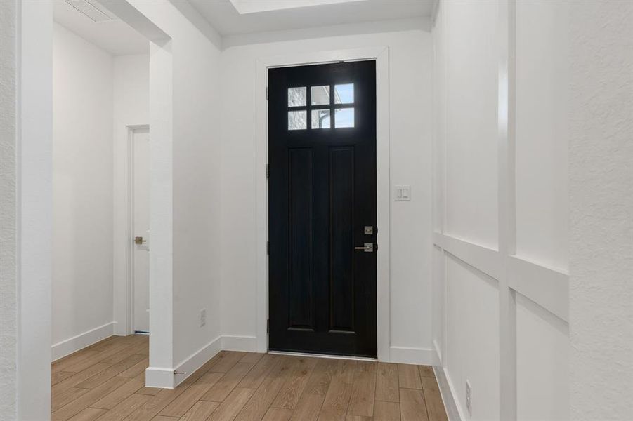 Front entry, notice the tile floors and detail trim on wall.  Hall leads to two secondary bedrooms and shared bath.