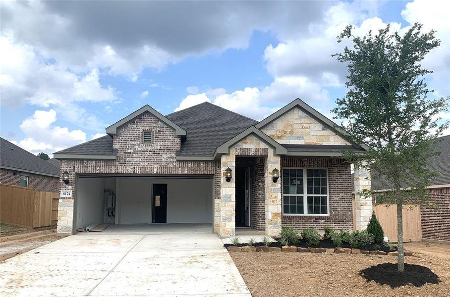 The Basswood has a beautiful arch around the front door entry and unique stone and brick design on the front of the house.