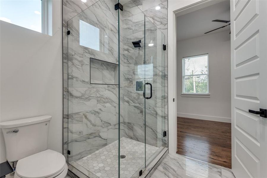 Glass enclosed stand up shower with natural stone.