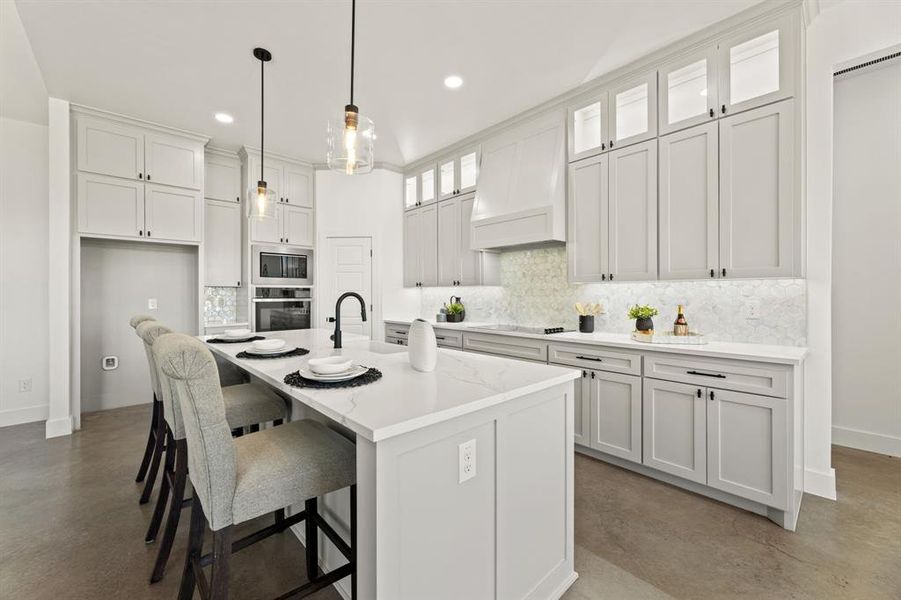Kitchen with an island with sink, white cabinetry, custom exhaust hood, and black appliances