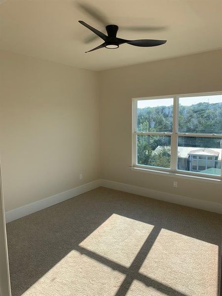 Carpeted spare room with ceiling fan