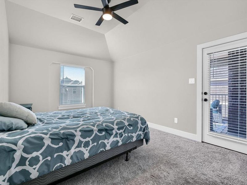 Bedroom featuring ceiling fan, vaulted ceiling, carpet floors, and access to exterior