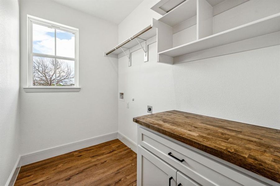 Laundry room featuring hookup for an electric dryer, dark hardwood / wood-style flooring, cabinets, and hookup for a washing machine