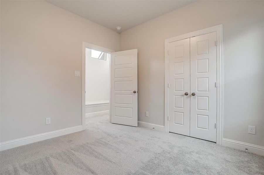 Unfurnished bedroom with light colored carpet and a closet