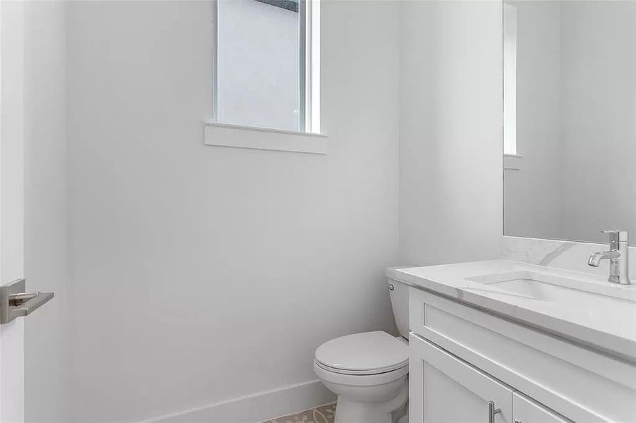 Bathroom featuring tile patterned floors, toilet, and vanity