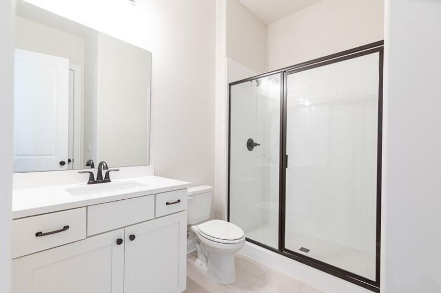 Bathroom with vanity with extensive cabinet space, and walk-in shower.  Photo not actual home, but previously built Mansfield plan.