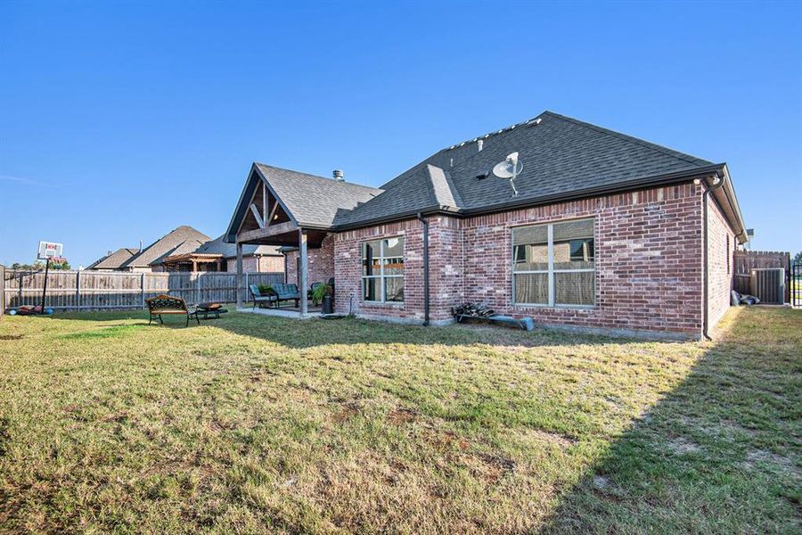 Rear view of property featuring a patio area and a lawn