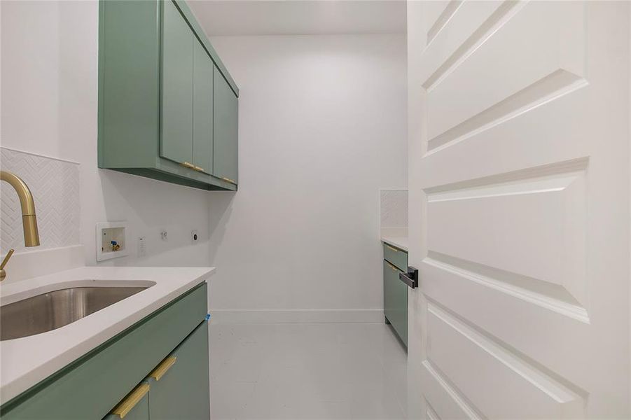 Laundry area with sink, cabinets, hookup for an electric dryer, washer hookup, and light tile patterned flooring