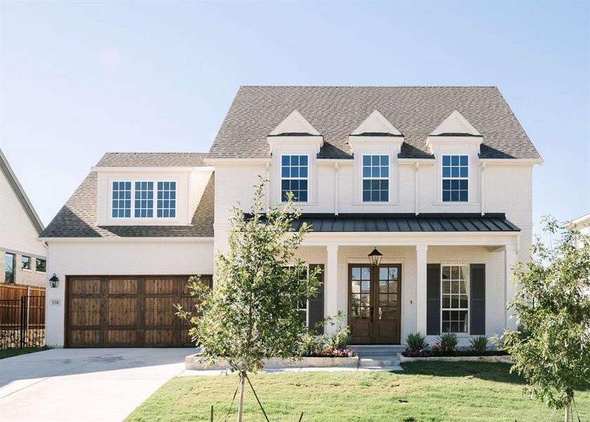 View of front of home with a front lawn and a garage