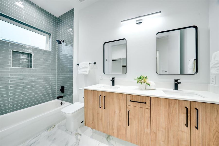 Full bathroom featuring toilet, tiled shower / bath combo, and vanity