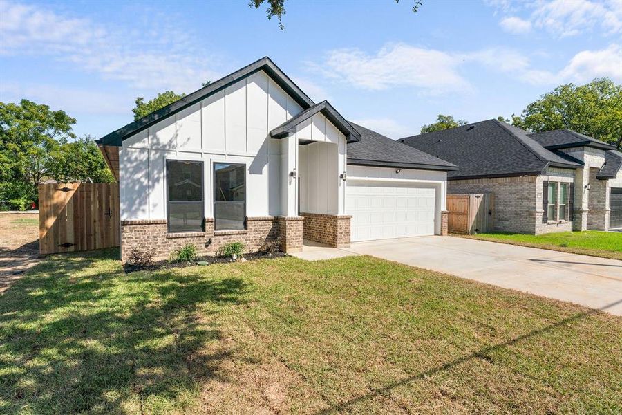 View of front of house with a garage and a front lawn