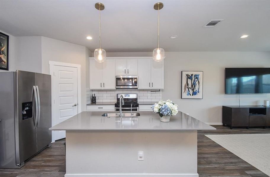 View of the kitchen area with an island and modern appliances.