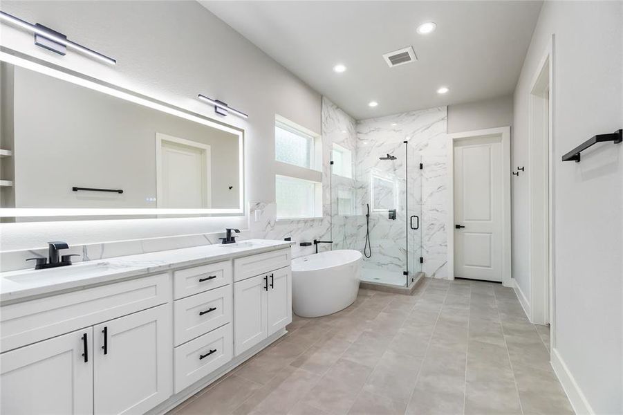 The spa-like Primary Bathroom is a real beauty- check out the lighted mirror!