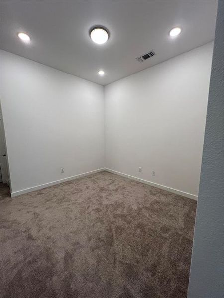 Spare room featuring dark colored carpet