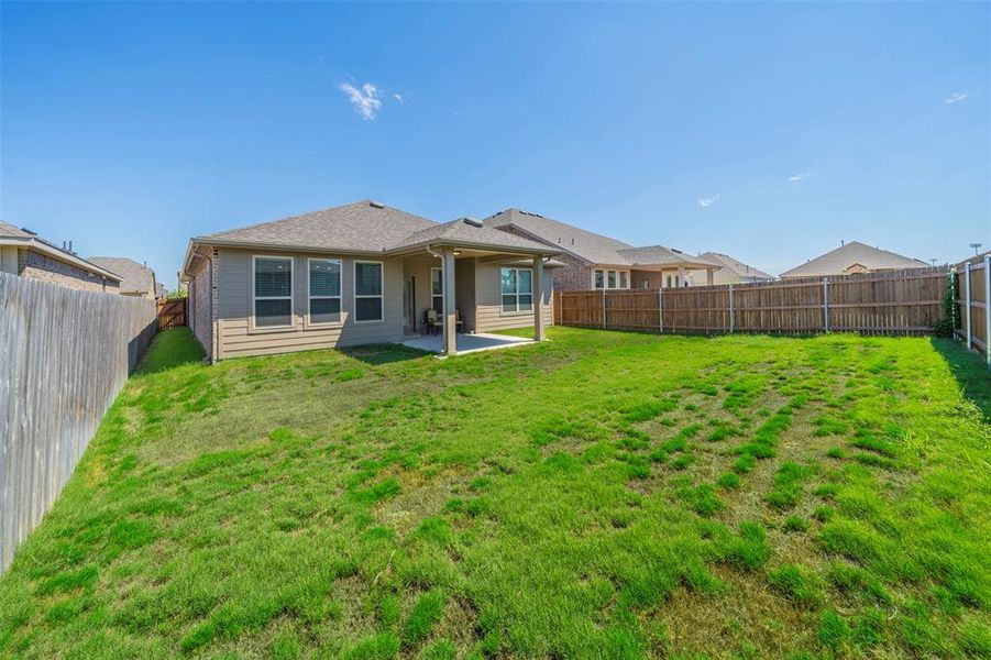 Rear view of house with a yard and a patio area