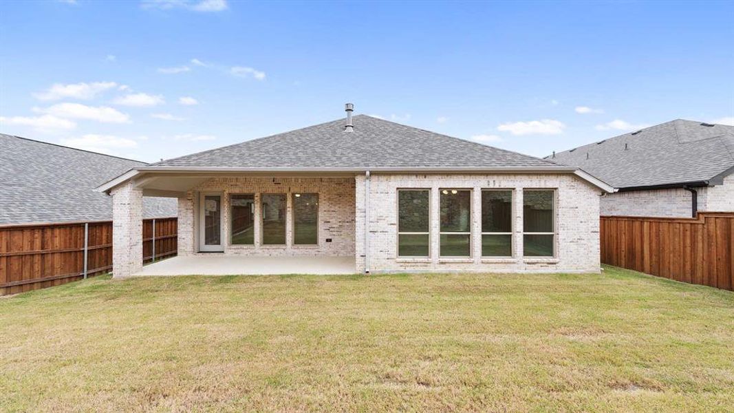 Rear view of property with a yard and a patio