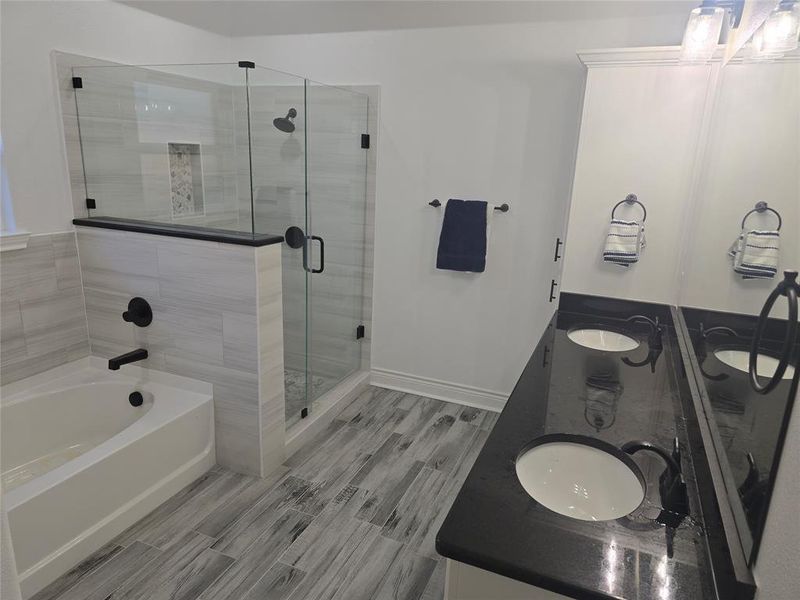 Bathroom featuring shower with separate bathtub and vanity