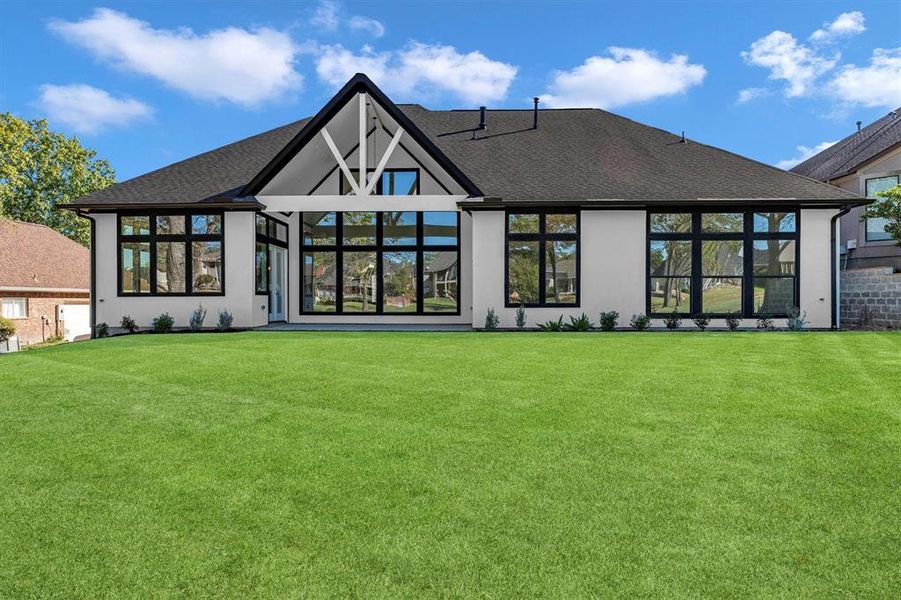 Back view of 164 Somerton from the golf course shows the many large, black framed windows throughout the back of the house.