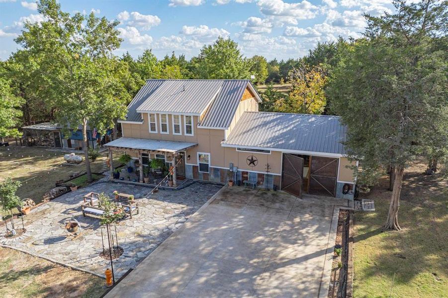 Front view of property with an outdoor fire pit and a patio area