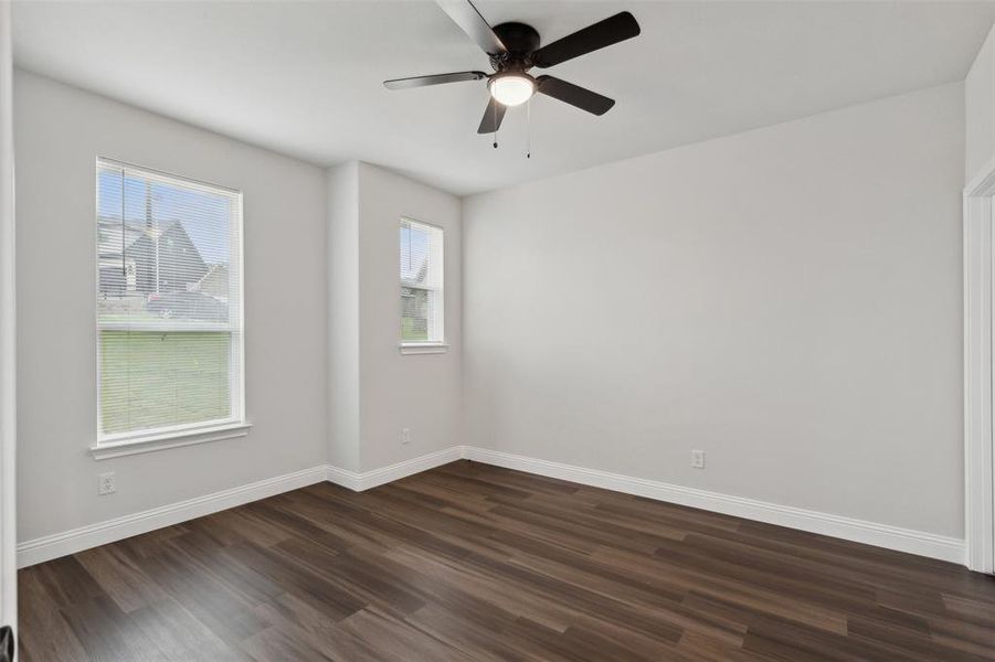 Unfurnished room featuring ceiling fan and dark hardwood / wood-style floors