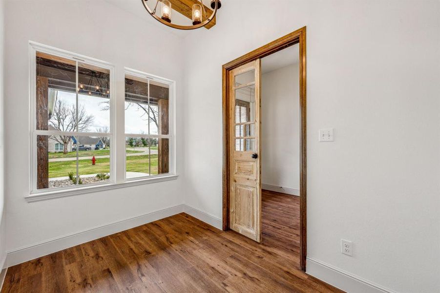 Unfurnished bedroom with hardwood / wood-style flooring and a chandelier