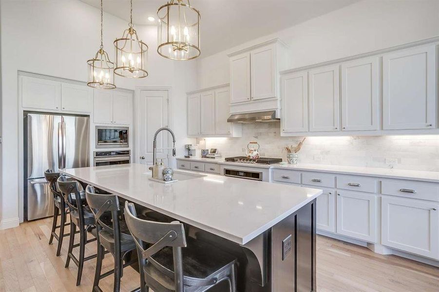 Kitchen with white cabinetry, a center island with sink, sink, and appliances with stainless steel finishes